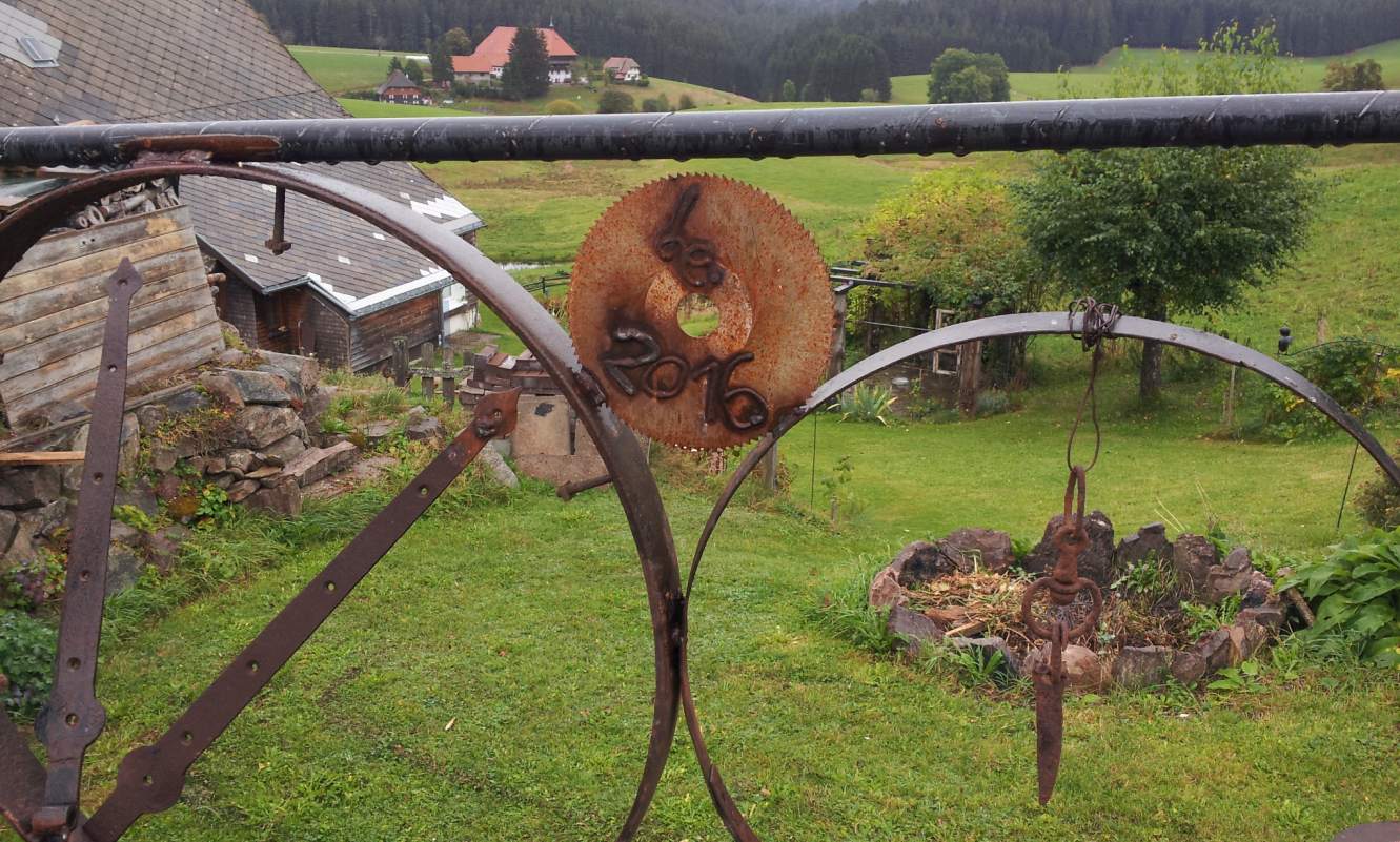 Bildtitel: Kunstvoll geschmiedeter Zaun mit integriertem Kreissägeblatt und Jahreszahl 2018