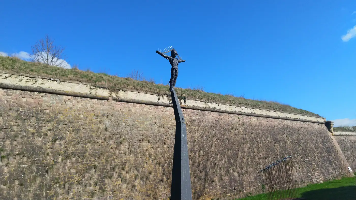 Bildtitel: Stahlskulptur vor Festungsmauer