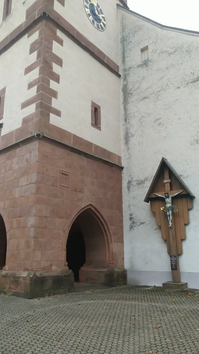 Bildtitel: St. Afra Kirchturm und Holzkreuz mit Christusfigur in Mühlenbach
