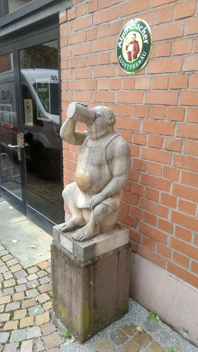 Bildtitel: Skulptur „Biertrinker“ von Thomas Dreilich vor Alpirsbacher Klosterbräu